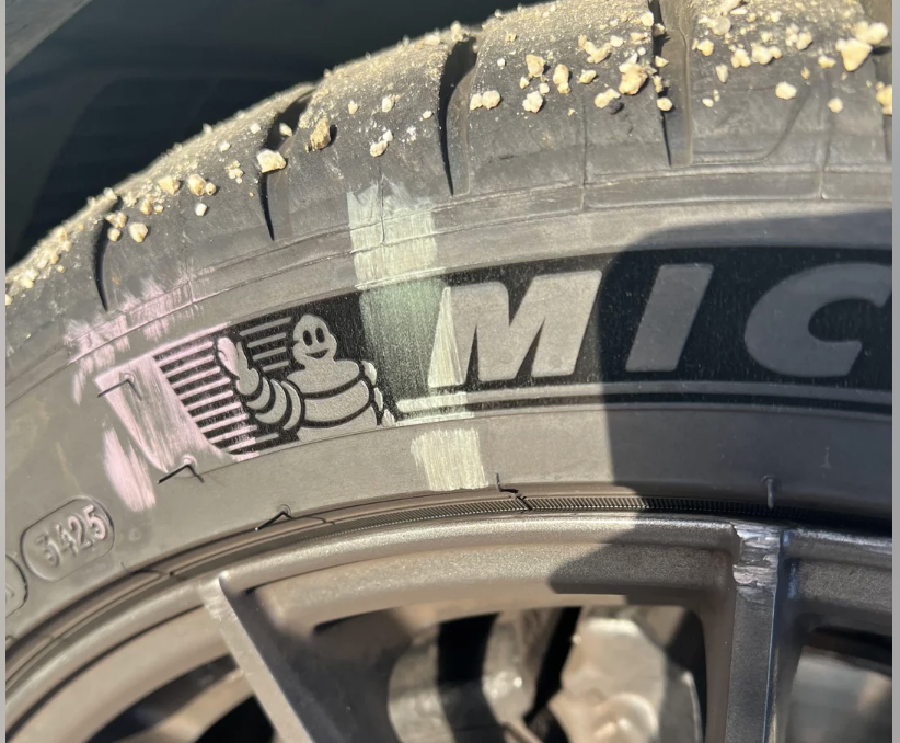 Chalk line on Michelin tire sidewall showing scuff marks from sidewall roll — evidence of underinflation